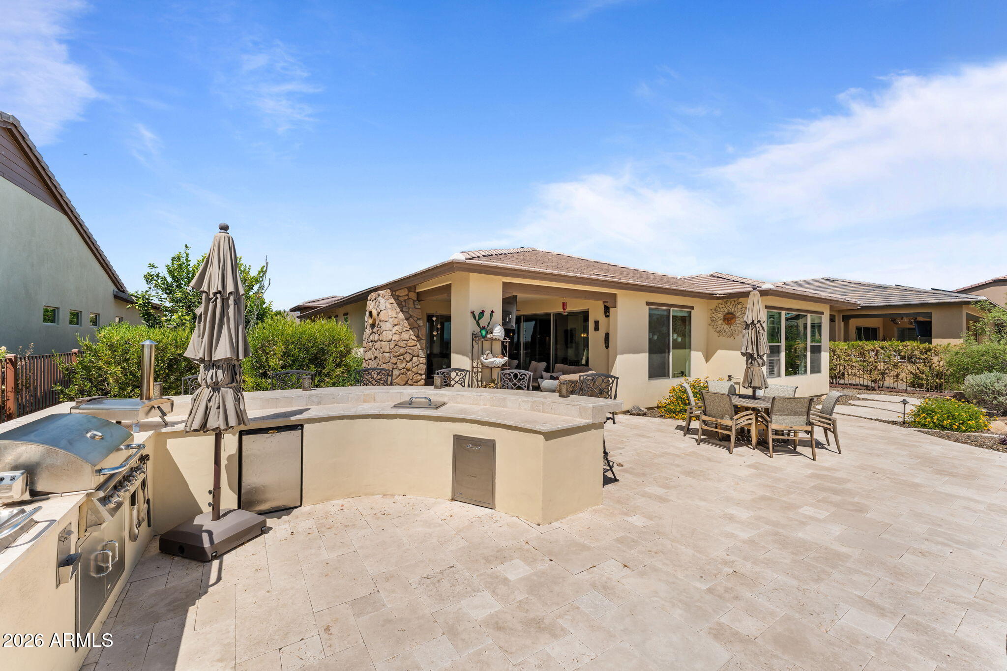 3855 Gold Ridge Road Wickenburg, AZ 85390 - Photo 33 of 38 a view of a patio with table and chairs under an umbrella next to a yard