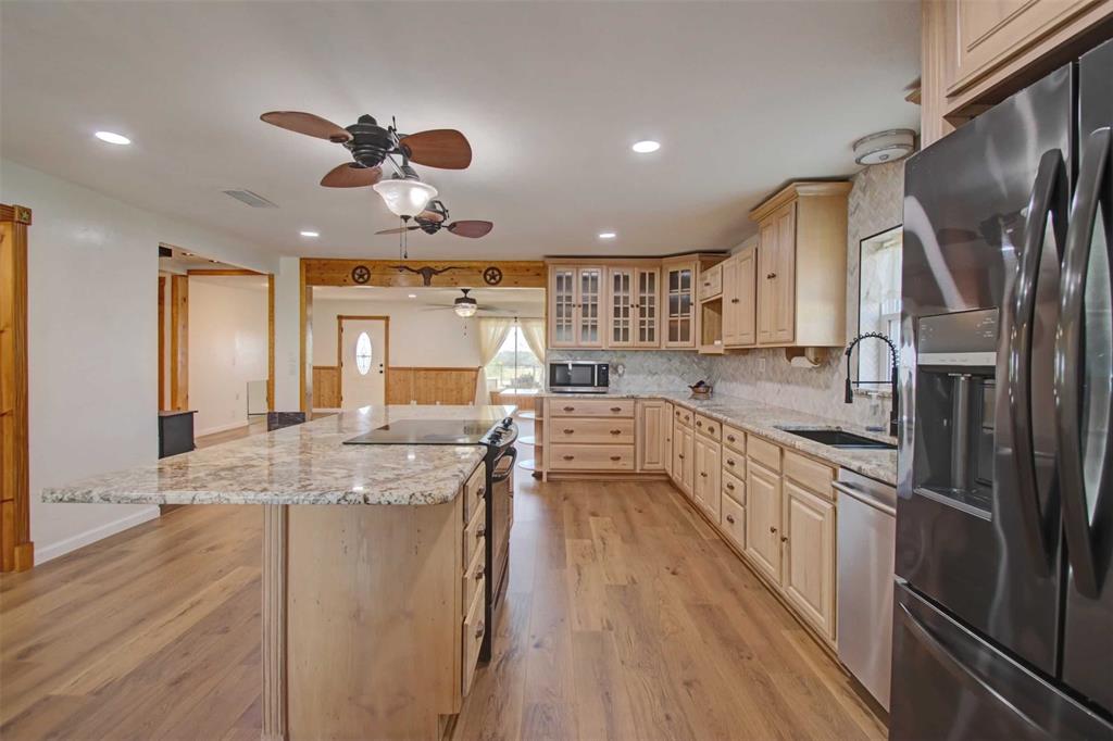 3559 Springfield Road Springtown, TX 76082 - Photo 7 of 37 a kitchen with stainless steel appliances granite countertop a sink a stove and refrigerator