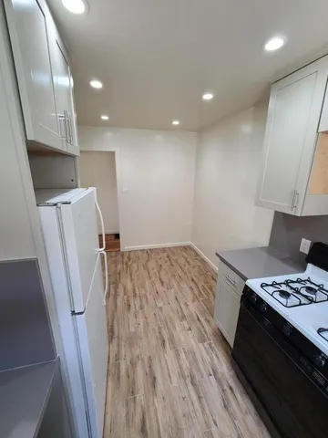a kitchen with a wooden floor and a stove top oven
