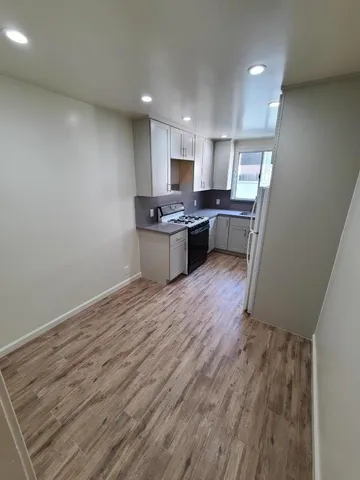 a kitchen with a sink and wooden floor
