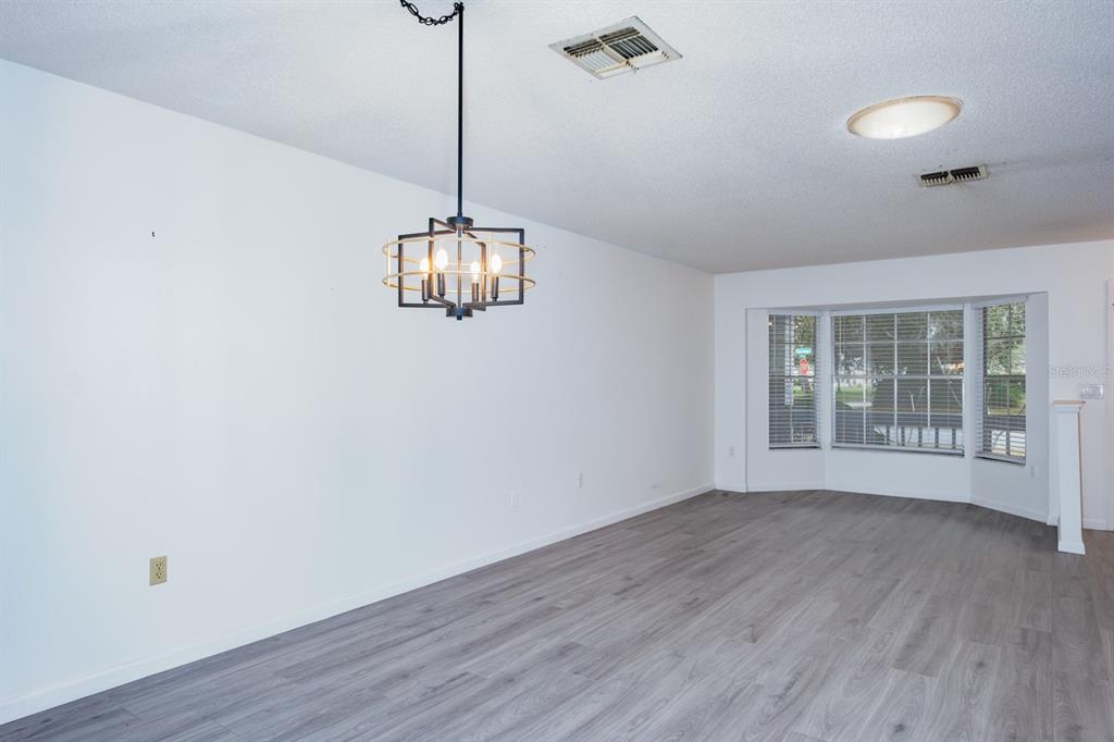 4814 Prince George Circle New Port Richey, FL 34655 - Photo 14 of 75 a view of an empty room with wooden floor and a window