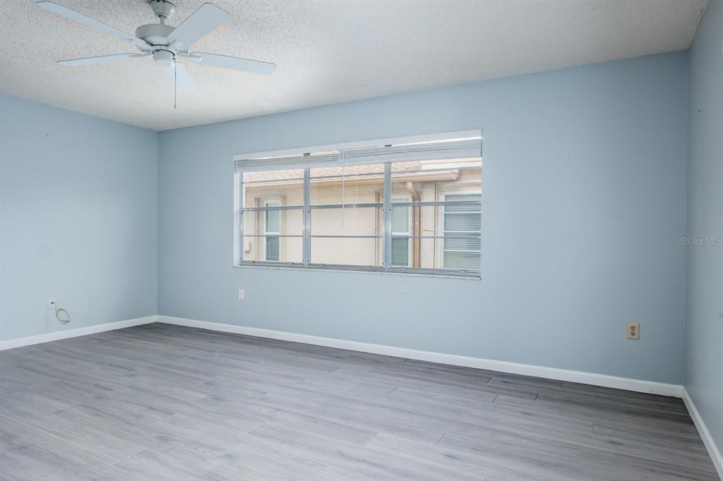 4814 Prince George Circle New Port Richey, FL 34655 - Photo 19 of 75 a view of an empty room with wooden floor and a window