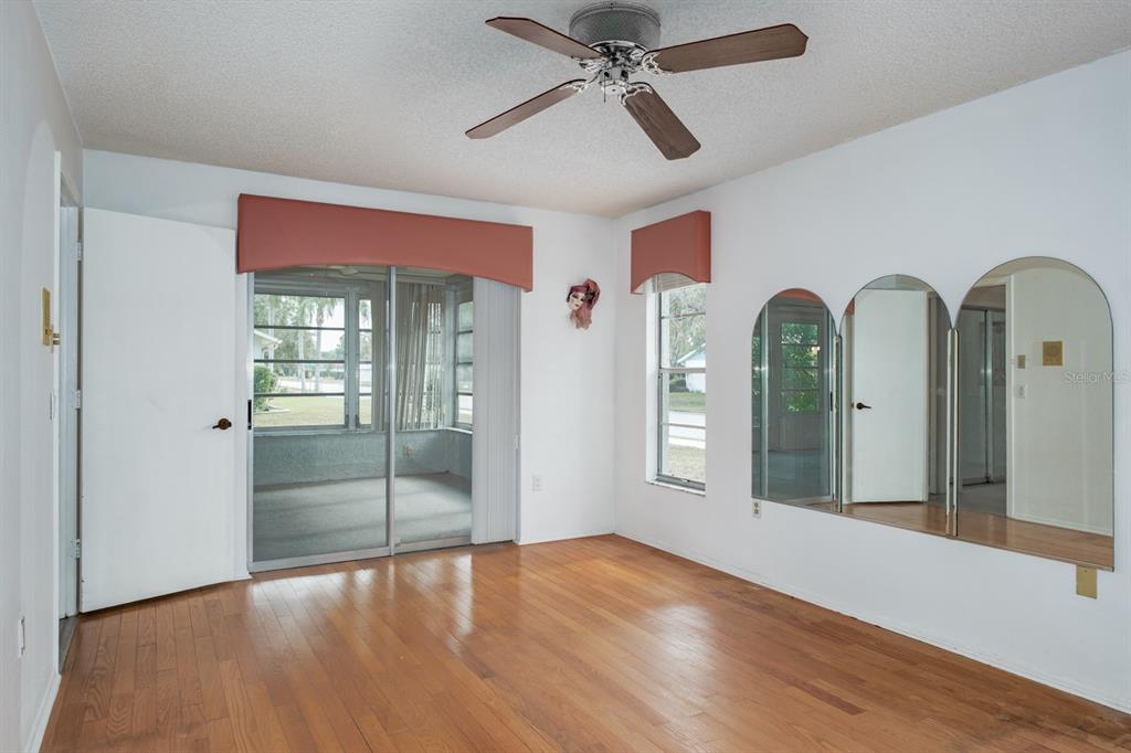 4814 Prince George Circle New Port Richey, FL 34655 - Photo 29 of 75 a view of empty room with wooden floor and fan