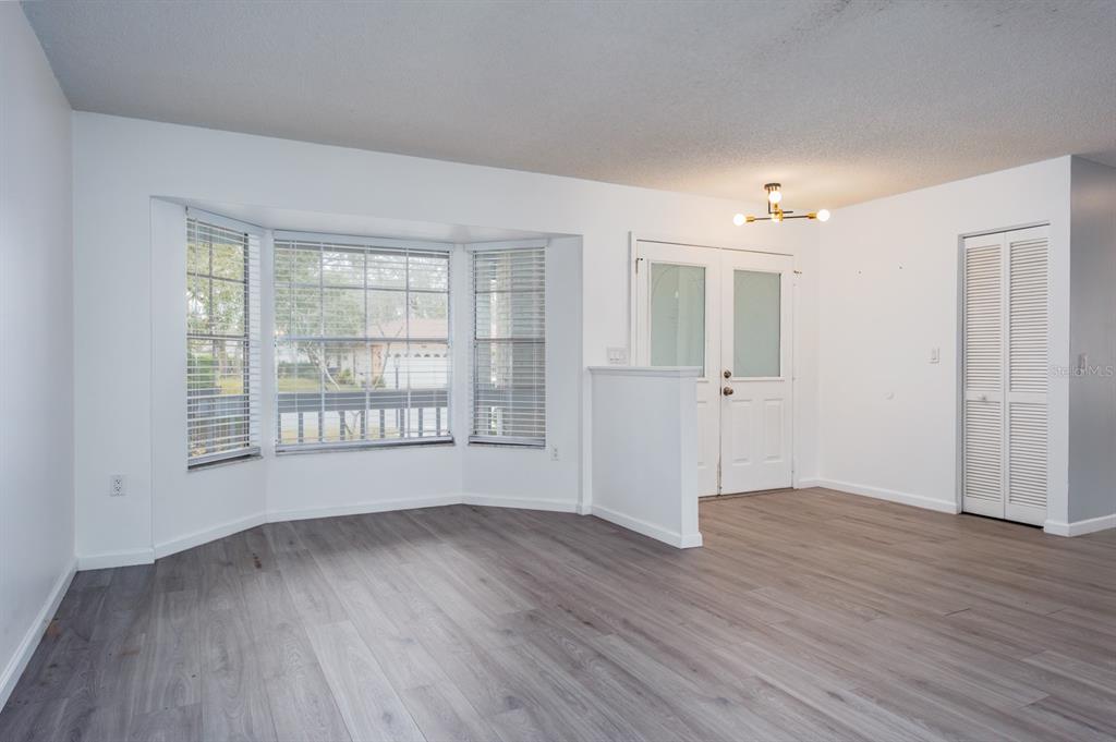 4814 Prince George Circle New Port Richey, FL 34655 - Photo 8 of 75 a view of an empty room with wooden floor and a window