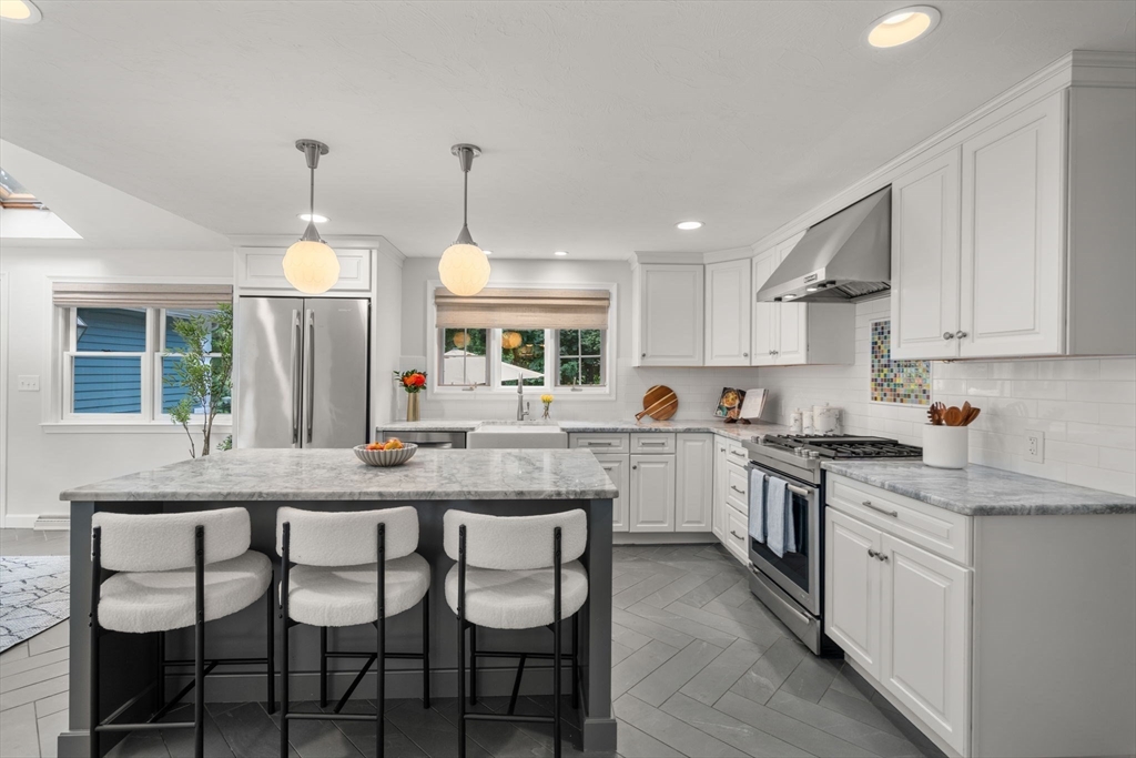 429 Warren Street Needham, MA 02492 - Photo 12 of 40 a kitchen with granite countertop wooden floor cabinets and dining table