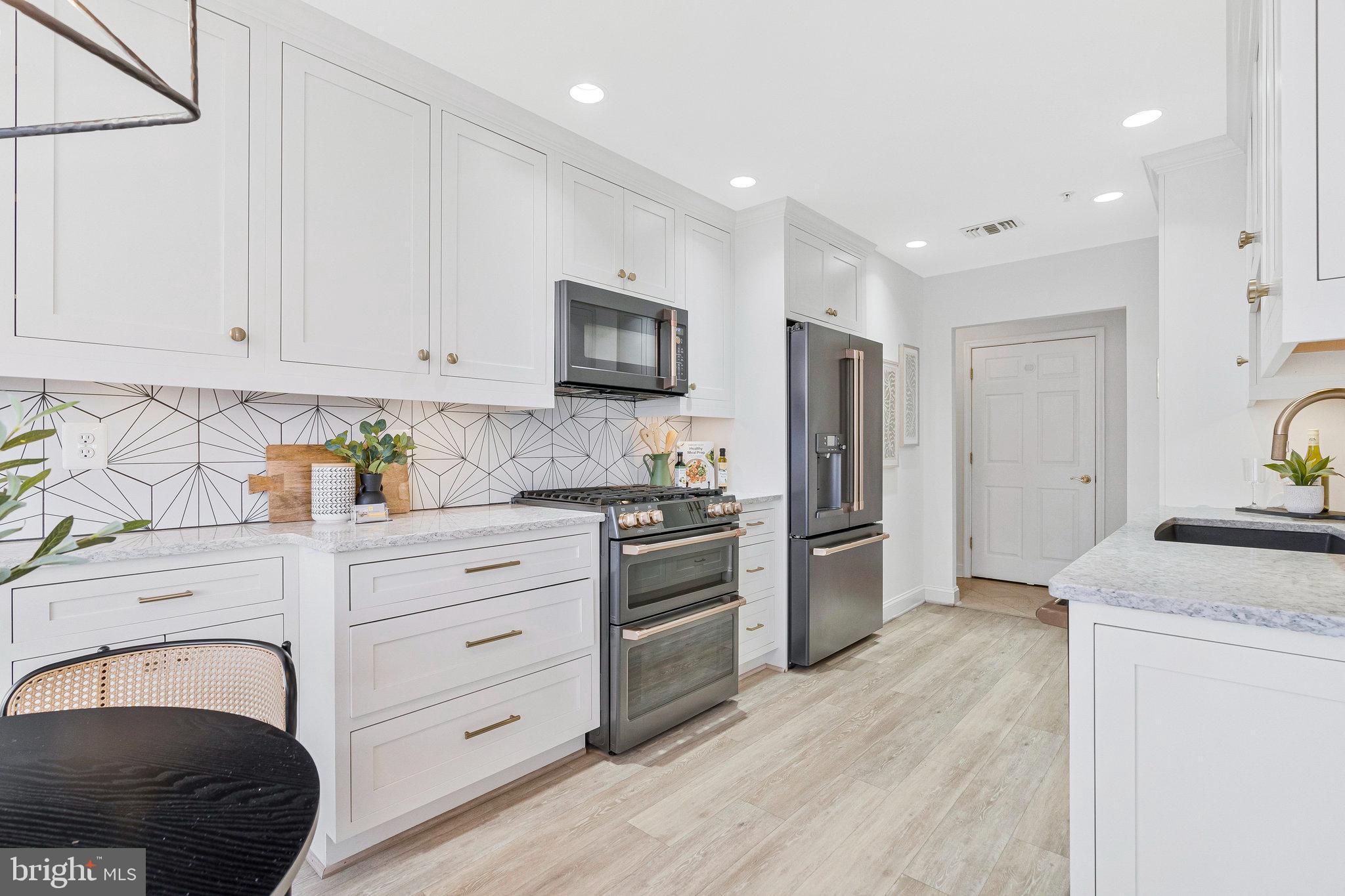 11776 Stratford House Place, Unit 807 Reston, VA 20190 - Photo 4 of 25 a kitchen with granite countertop white cabinets and stainless steel appliances
