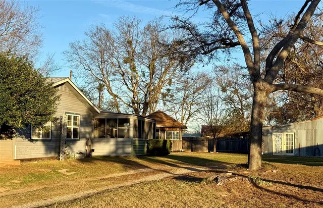 a tree in front of a white house