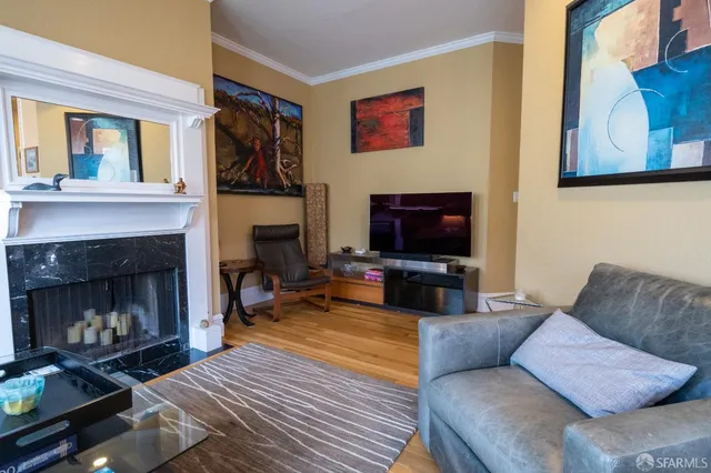a living room with furniture a flat screen tv and a fireplace