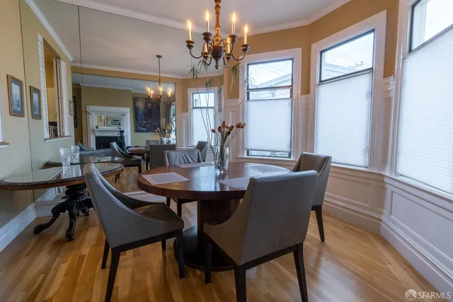 a dining room with furniture a chandelier and wooden floor