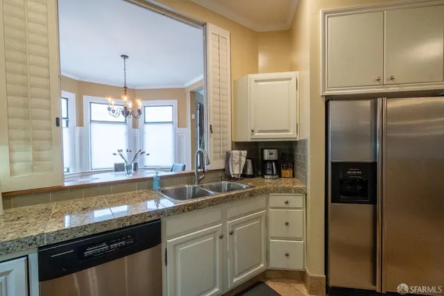 a kitchen with stainless steel appliances granite countertop a sink a stove and refrigerator