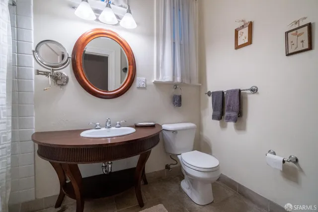 a bathroom with a toilet a sink and a mirror
