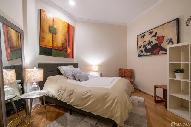 a bedroom with a bed and wooden floor