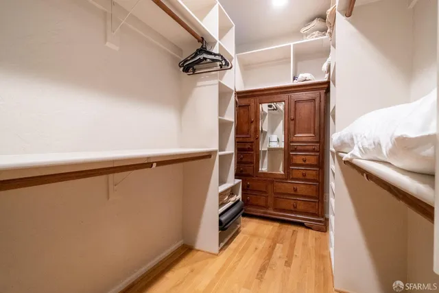 a view of walk in closet with clothes and shoes