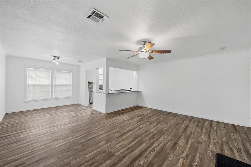 3104 Fadal Avenue Waco, TX 76708 - Photo 6 of 17 wooden floor in an empty room with a kitchen