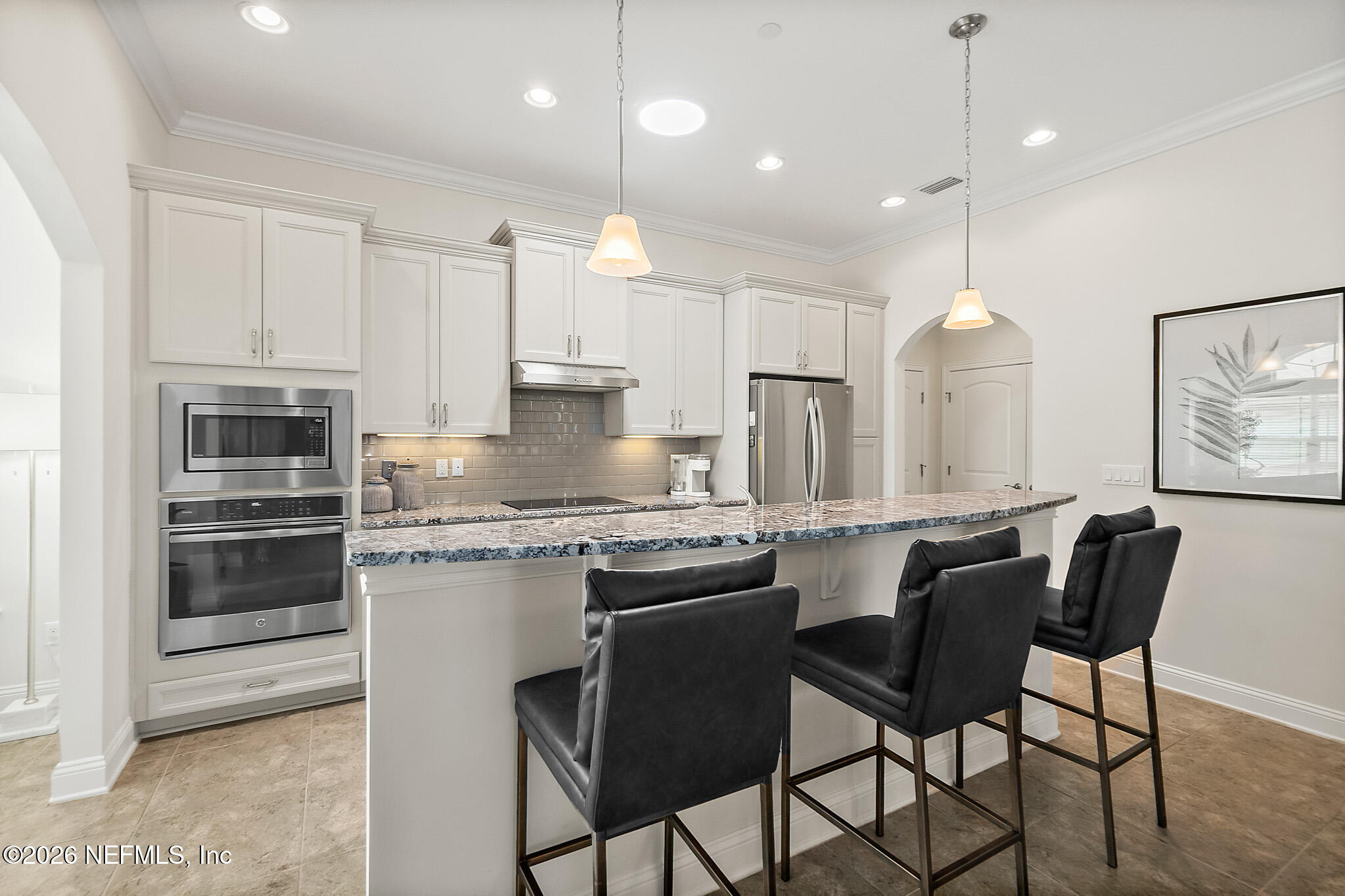 44 Utina Way St. Augustine, FL 32084 - Photo 12 of 48 a kitchen with stainless steel appliances granite countertop a stove a sink a microwave a refrigerator and white cabinets with wooden floor