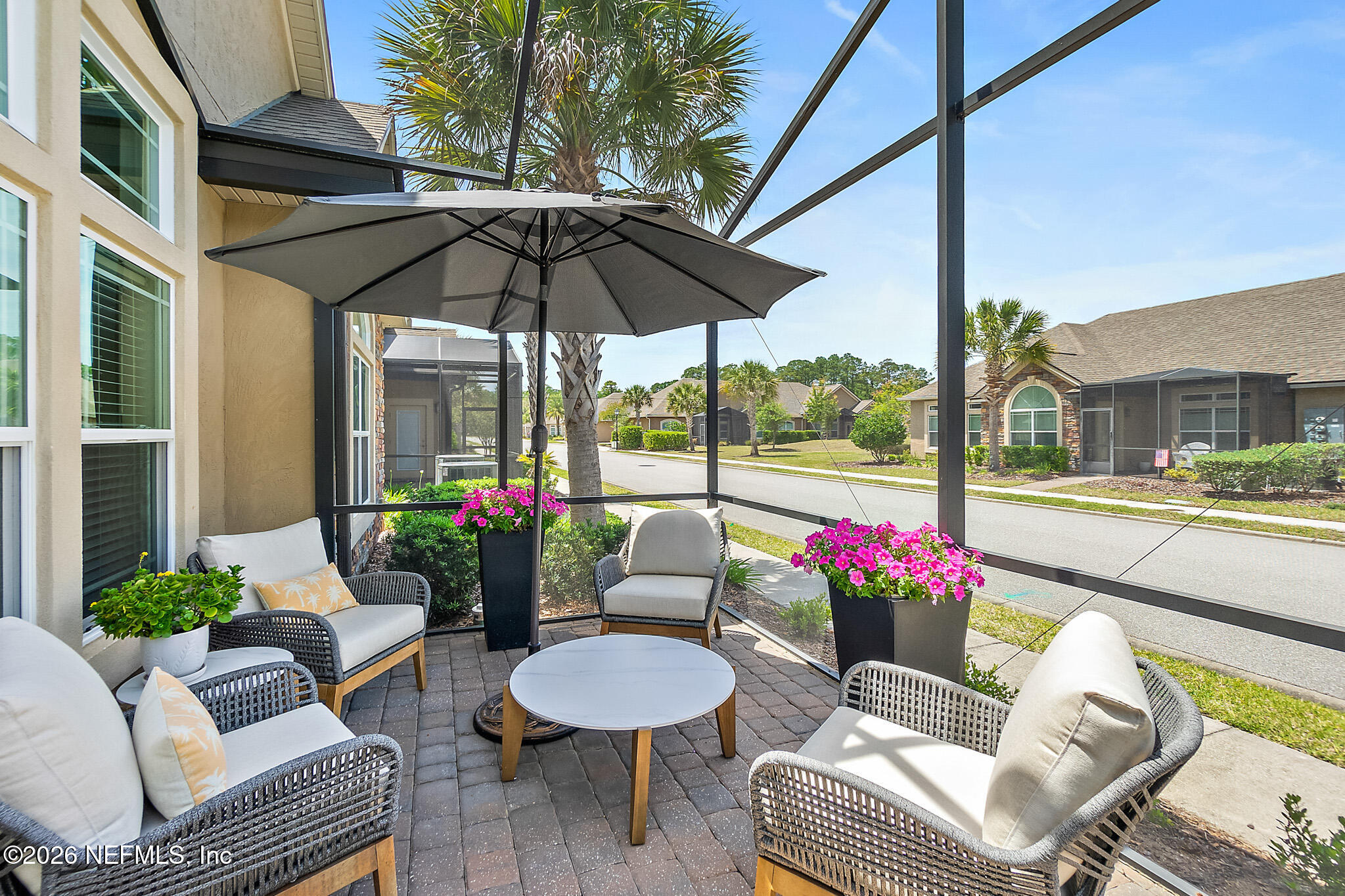 44 Utina Way St. Augustine, FL 32084 - Photo 30 of 48 a view of a patio with couches and table and chairs under an umbrella