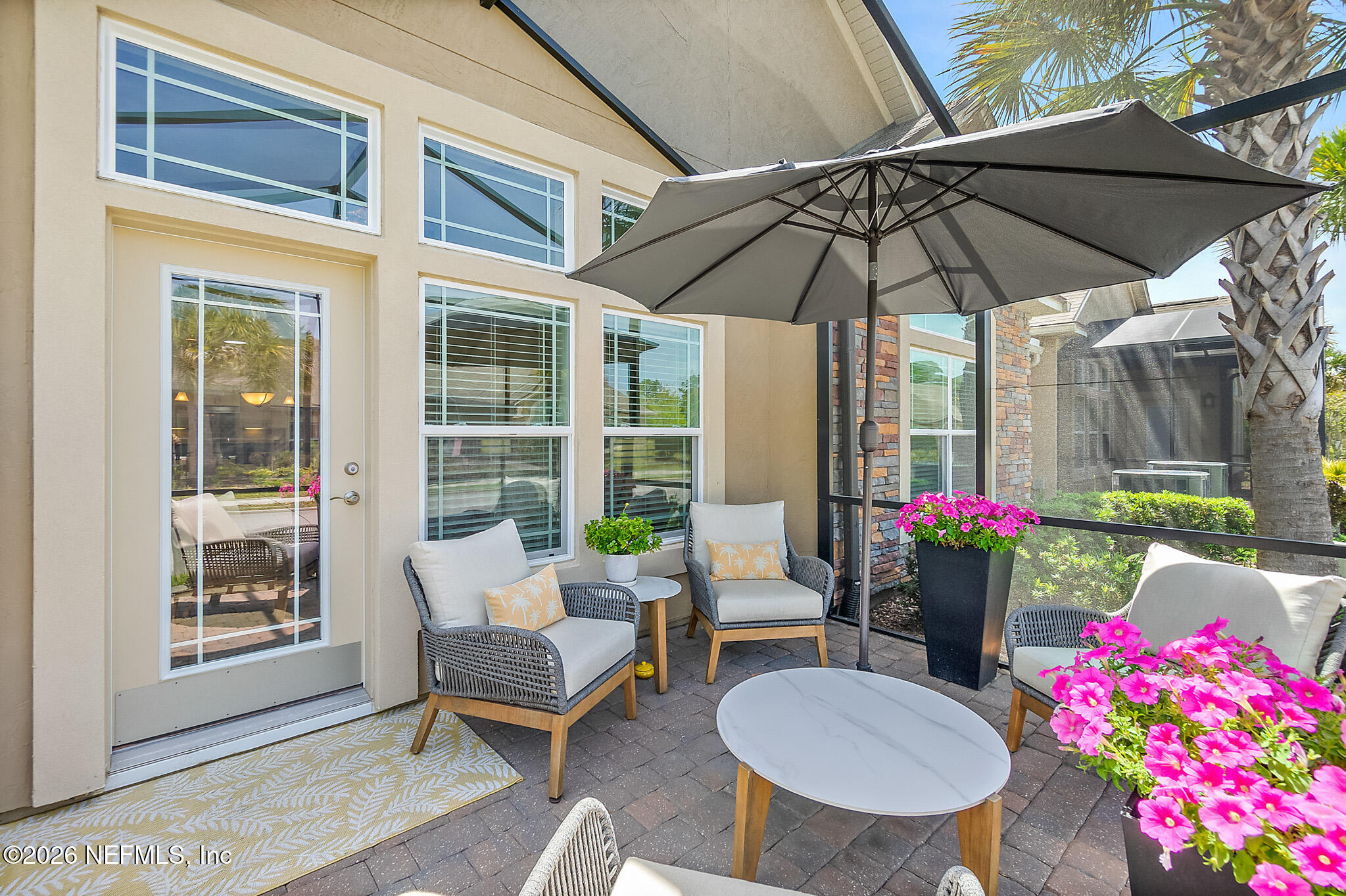 44 Utina Way St. Augustine, FL 32084 - Photo 31 of 48 a patio with a table and chairs under an umbrella