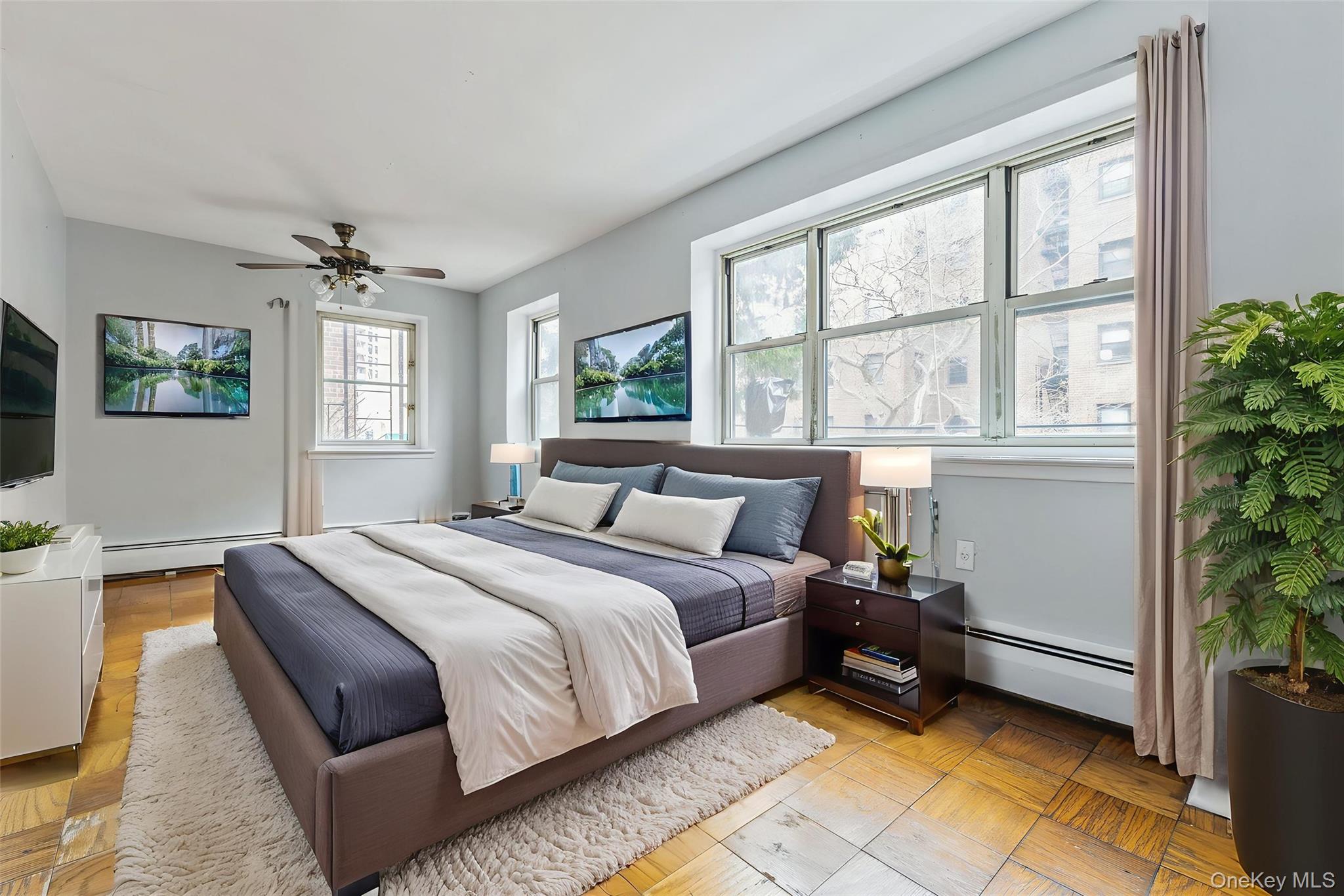 99-10 60th Avenue, Unit 1A Queens, NY 11368 - Photo 3 of 10 Bedroom featuring a baseboard radiator and a ceiling fan