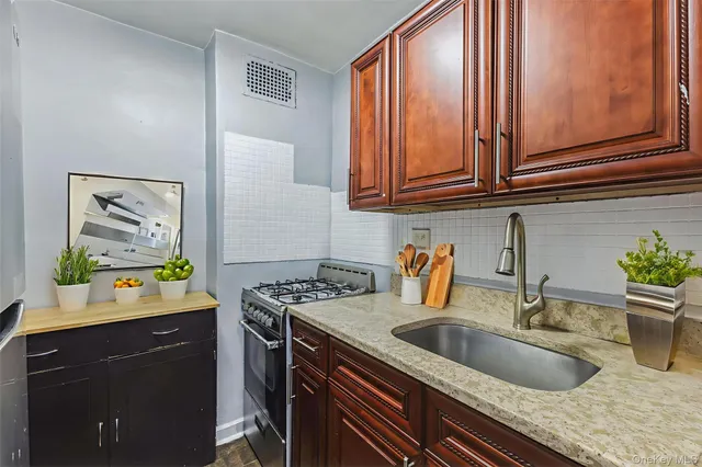 a kitchen with stainless steel appliances granite countertop a sink stove and cabinets