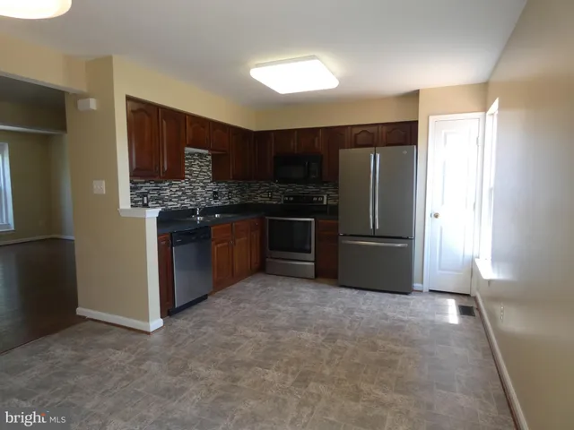 a kitchen with stainless steel appliances granite countertop a stove a refrigerator and a sink