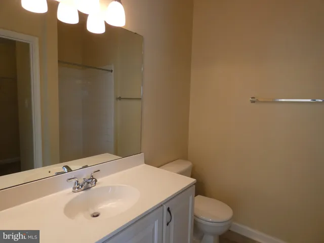 a bathroom with a sink a toilet and mirror
