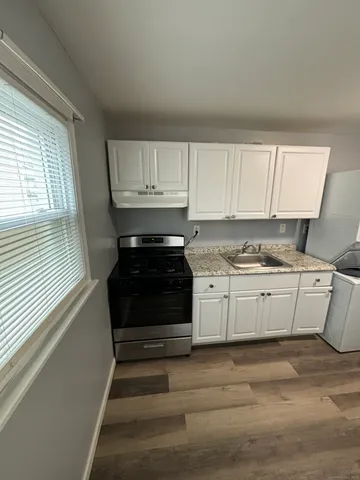 a kitchen with granite countertop white cabinets and appliances
