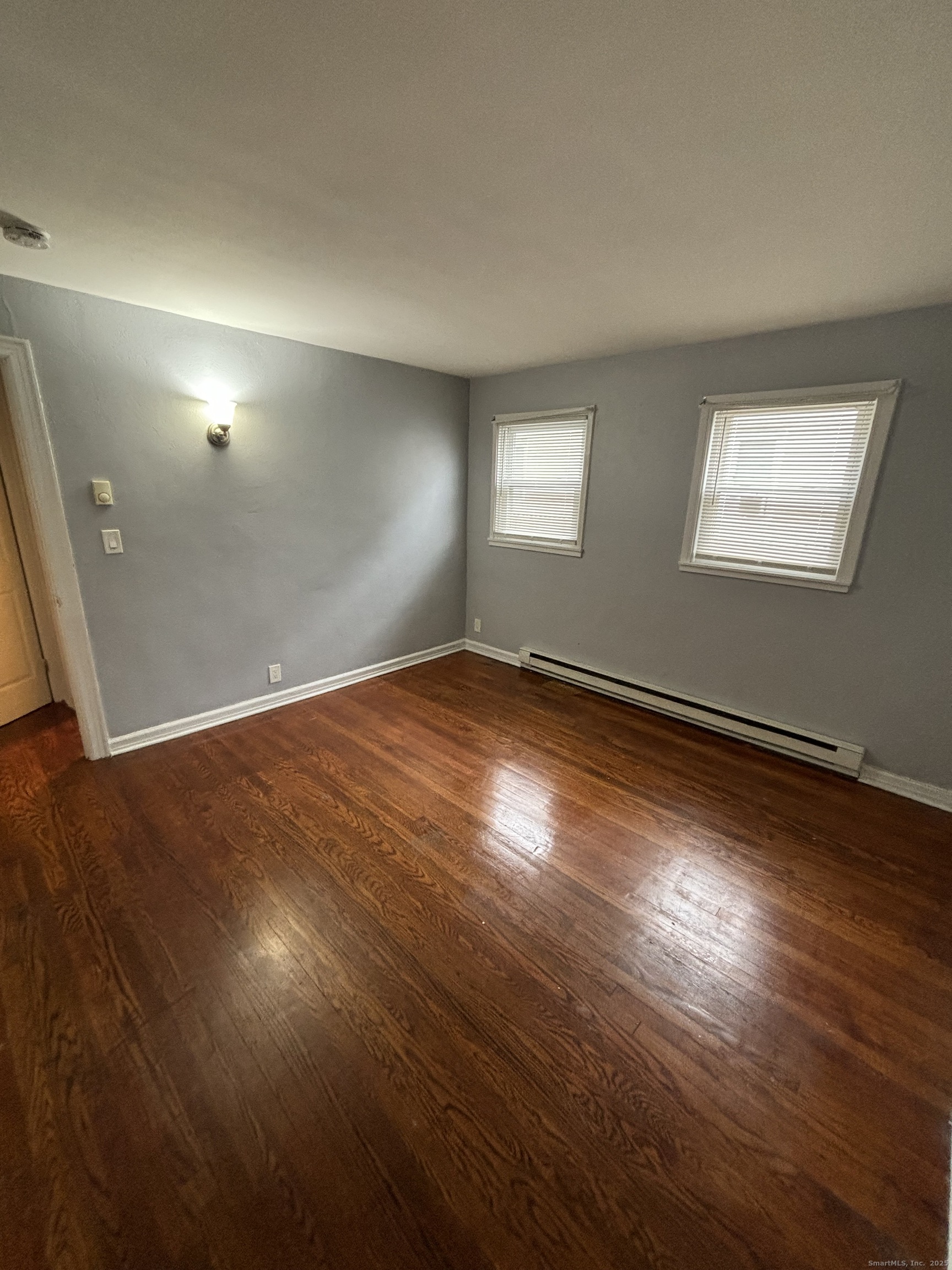 76 Birdsey Street, Unit 1R Bridgeport, CT 06610 - Photo 5 of 8 an empty room with wooden floor and windows