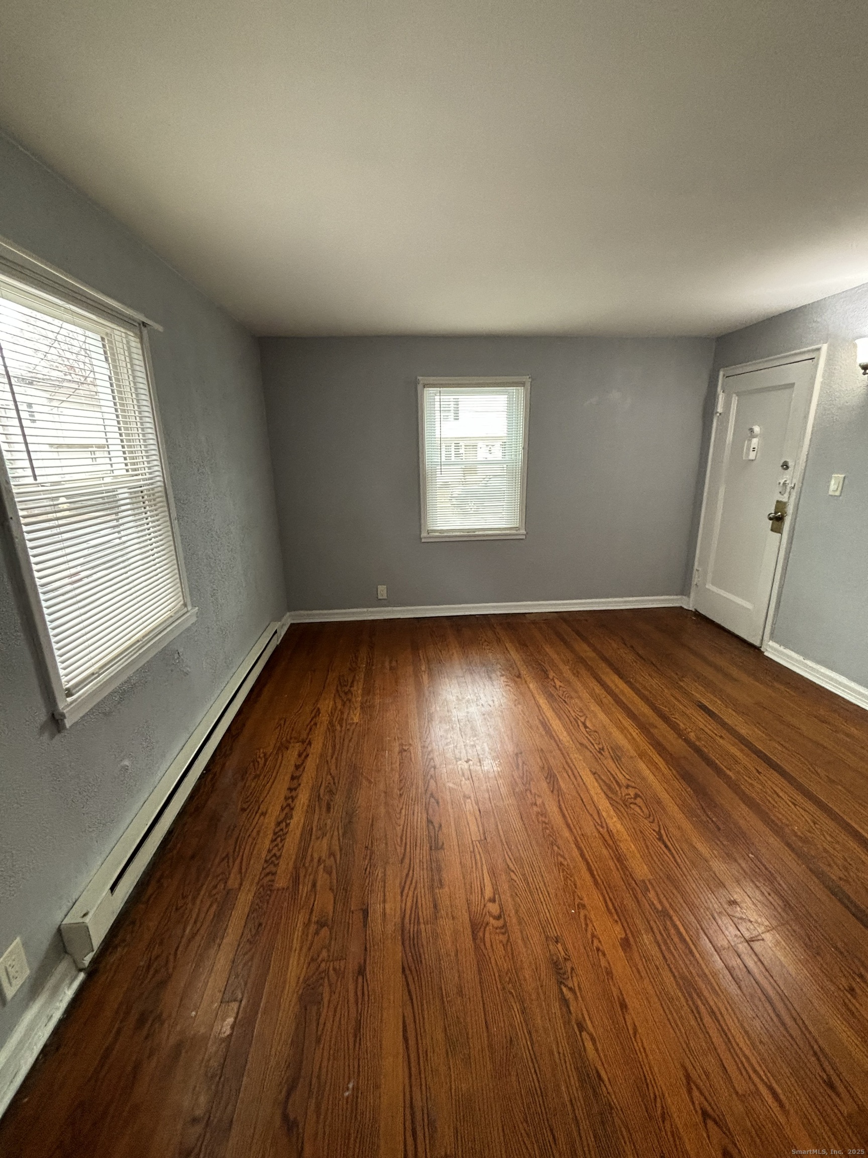 76 Birdsey Street, Unit 1R Bridgeport, CT 06610 - Photo 7 of 8 an empty room with wooden floor and windows