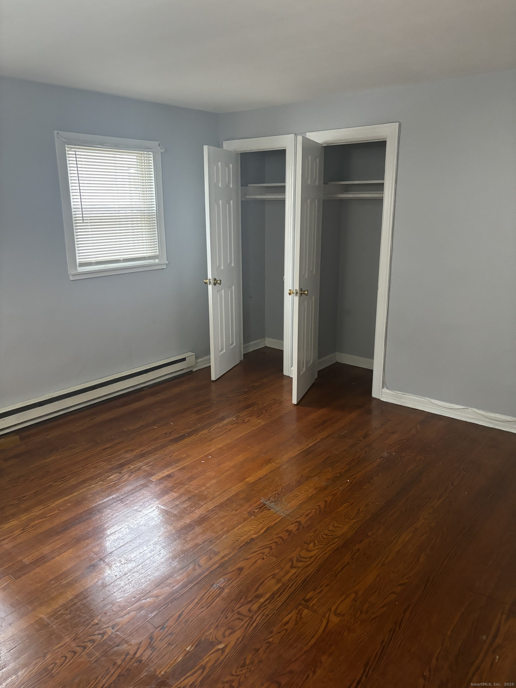 76 Birdsey Street, Unit 1R Bridgeport, CT 06610 - Photo 8 of 8 an empty room with wooden floor closet and windows