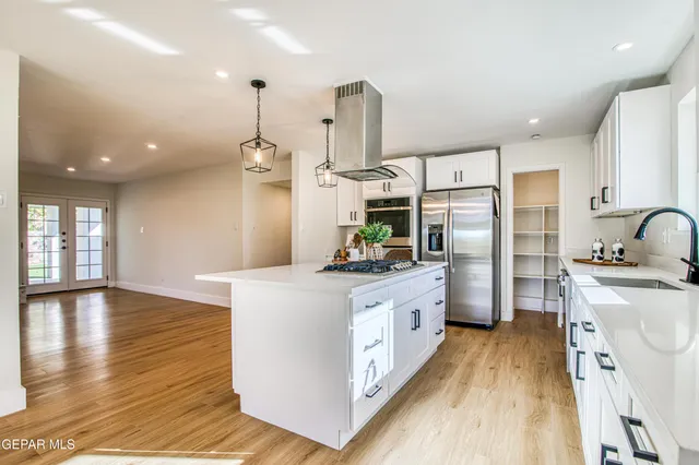 a kitchen with stainless steel appliances granite countertop a sink stove and wooden floor