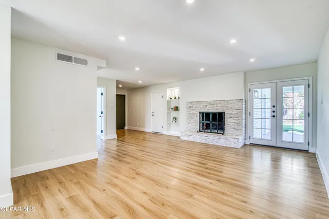 a view of a livingroom with wooden floor and a fireplace