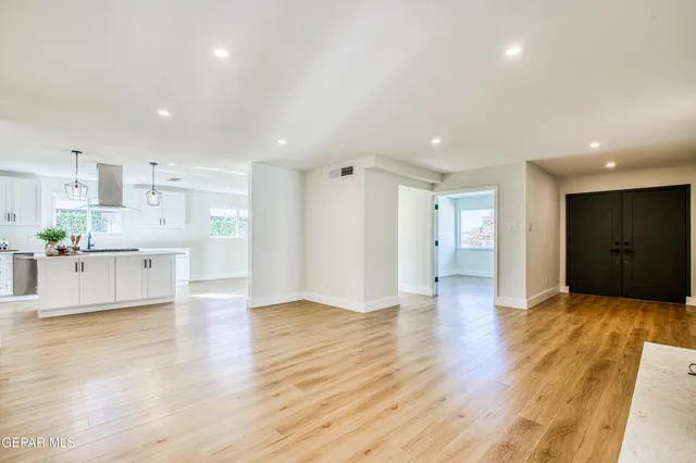 a view of kitchen with kitchen island wooden floor center island and stainless steel appliances