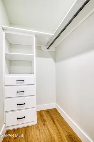 an empty room with an entryway and a chandelier fan