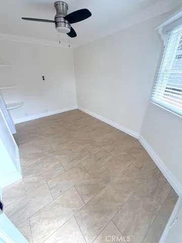 an empty room with a window and a ceiling fan