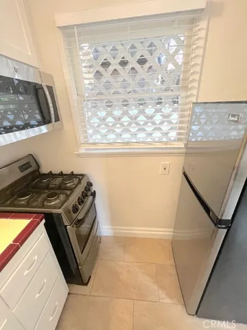 a kitchen with a stove a sink and a window