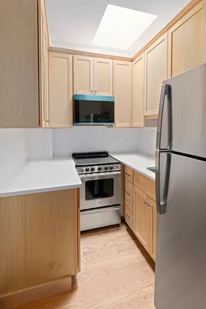 a kitchen with stainless steel appliances a refrigerator sink and microwave