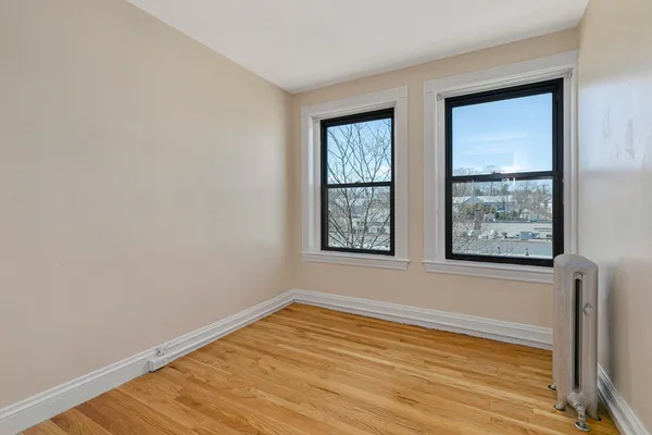 a view of a room with wooden floor and window