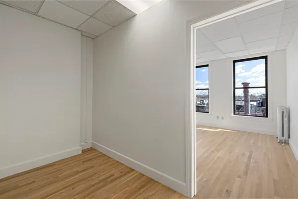 a view of a room with wooden floor and windows