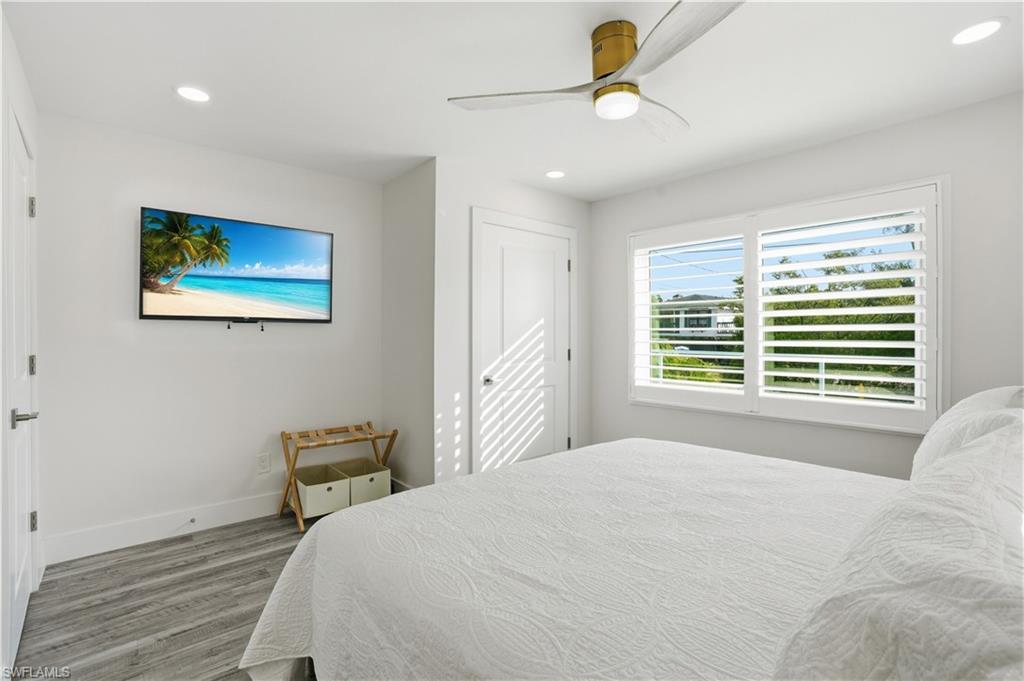 270 Dundee Road Fort Myers Beach, FL 33931 - Photo 28 of 48 Bedroom with wood finished floors, recessed lighting, and ceiling fan - Virtually Edited Image