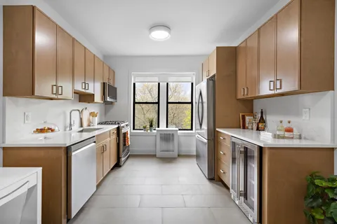 a kitchen with stainless steel appliances a stove a sink and white cabinets