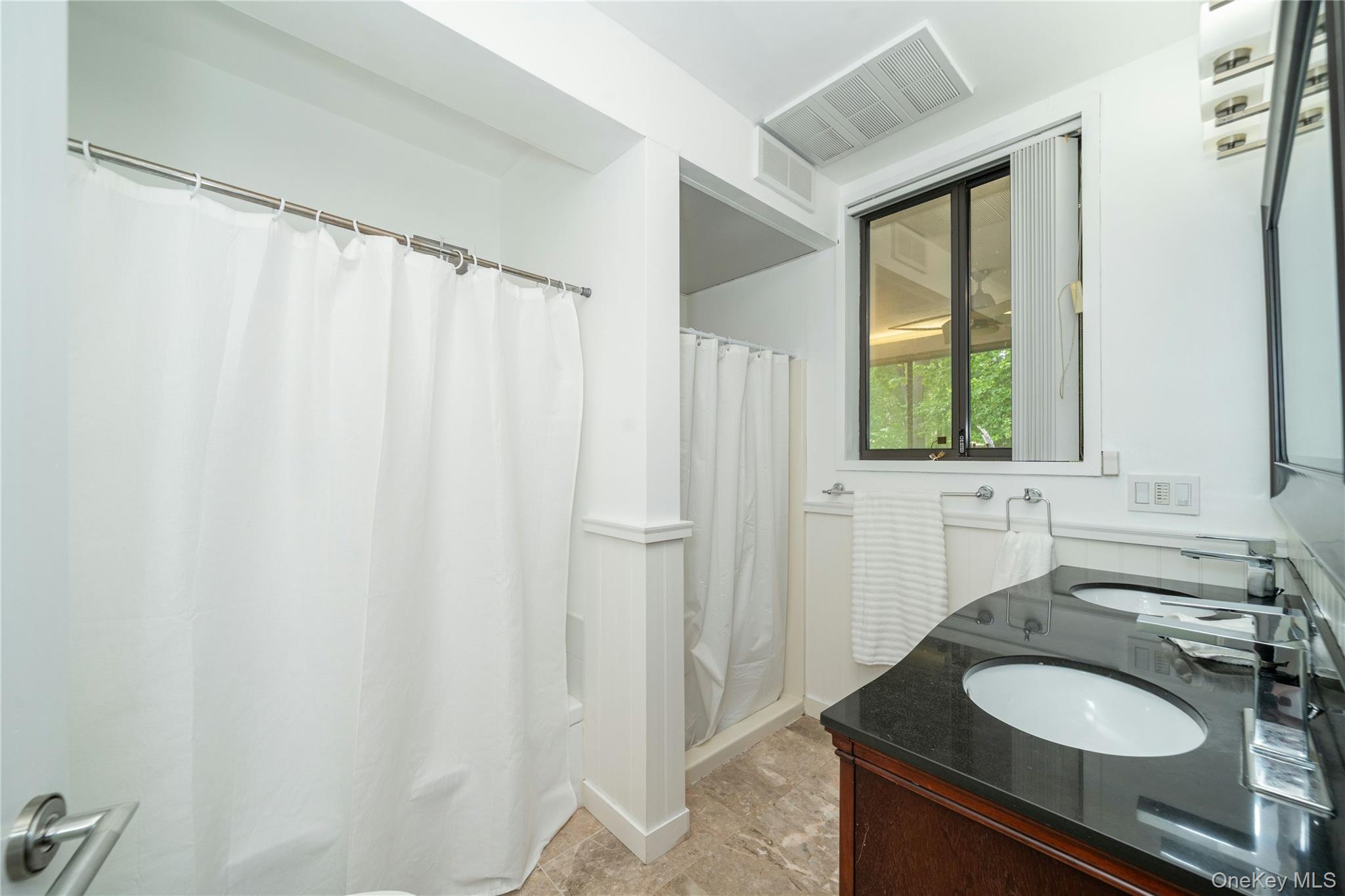 4 Half Mile Road Armonk, NY 10504 - Photo 14 of 28 Updated primary bathroom featuring a double vanity, separate bath and shower areas, and clean modern finishes with natural light.