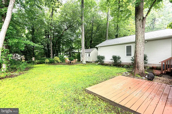 a view of a backyard with table and chairs with wooden fence and plants