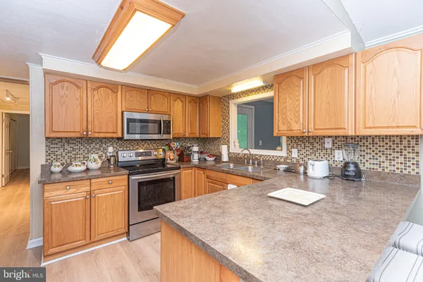 a kitchen with stainless steel appliances granite countertop a sink stove microwave and refrigerator