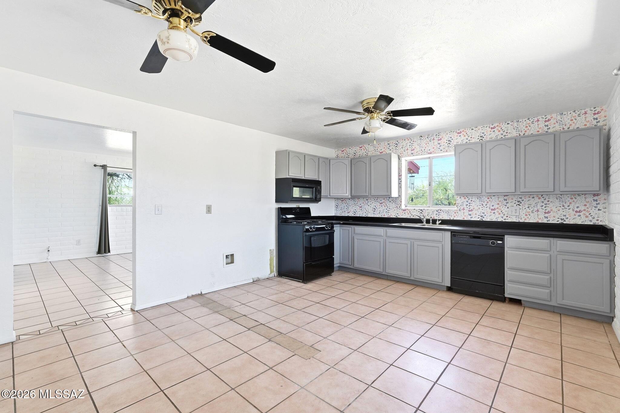 5125 South Missiondale Road Tucson, AZ 85706 - Photo 8 of 32 a kitchen with stainless steel appliances kitchen island granite countertop a refrigerator and a stove top oven