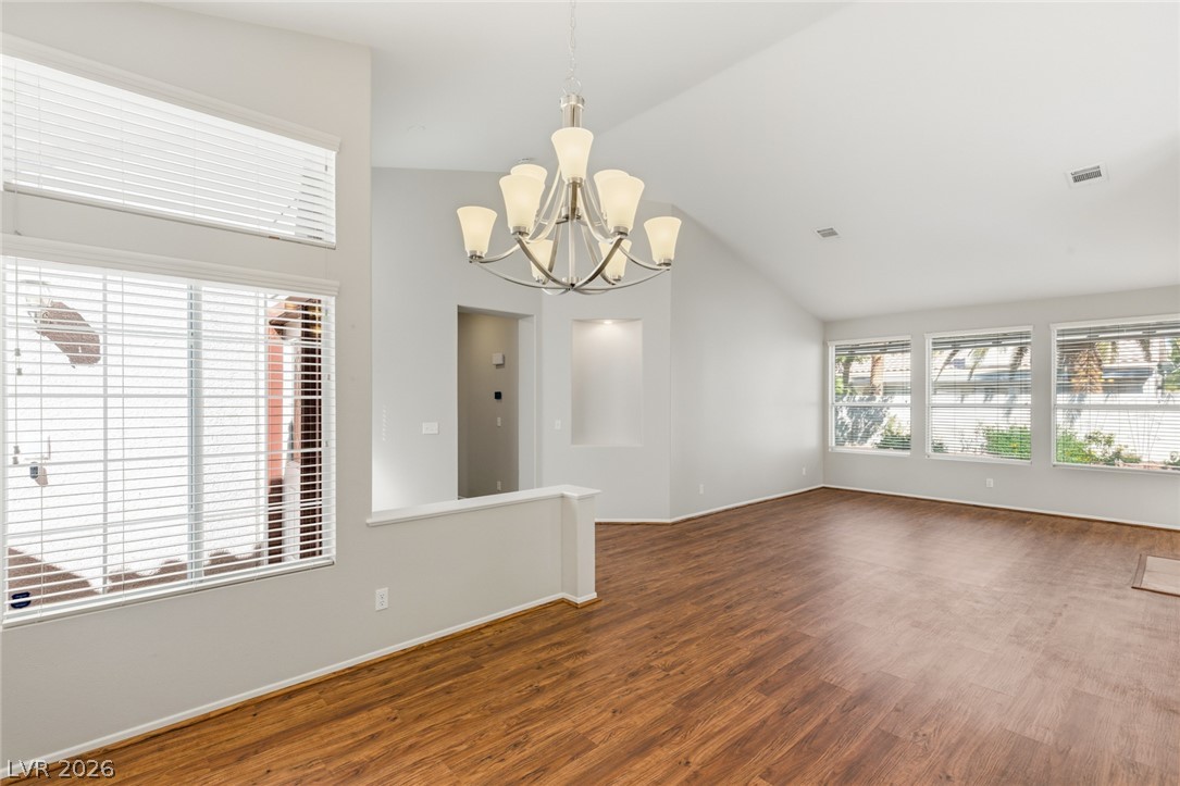 9034 Ridgepointe Way Henderson, NV 89074 - Photo 15 of 56 A spacious living area features rich wood flooring and vaulted ceilings illuminated by abundant natural light.