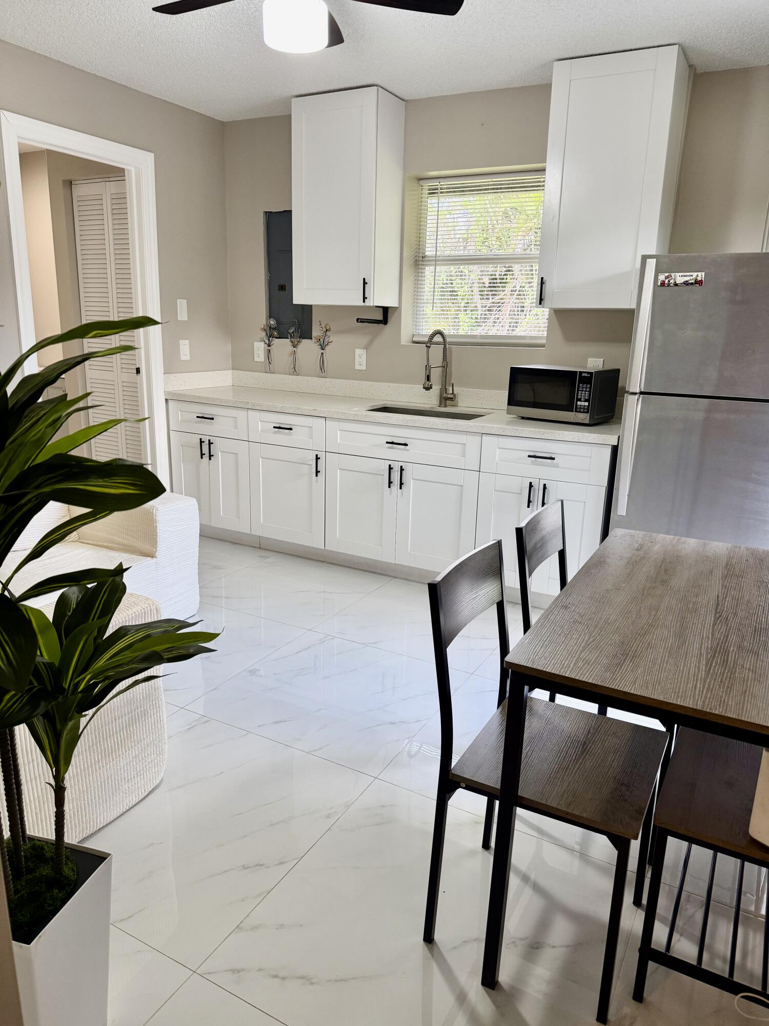14523 Flamingo Road Loxahatchee Groves, FL 33470 - Photo 49 of 50 a kitchen with a table chairs cabinets and appliances