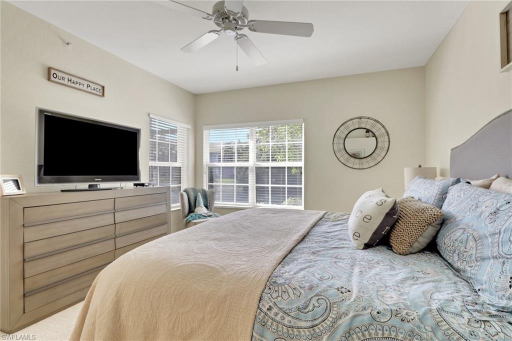 6923 Satinleaf Road North, Unit 101 Naples, FL 34109 - Photo 15 of 50 a bedroom with a bed and a flat tv screen on dresser