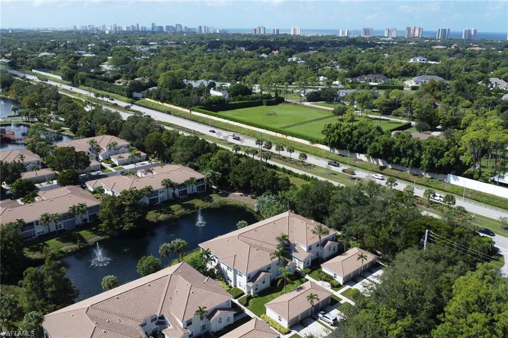 6923 Satinleaf Road North, Unit 101 Naples, FL 34109 - Photo 29 of 50 an aerial view of house with yard swimming pool and lake view