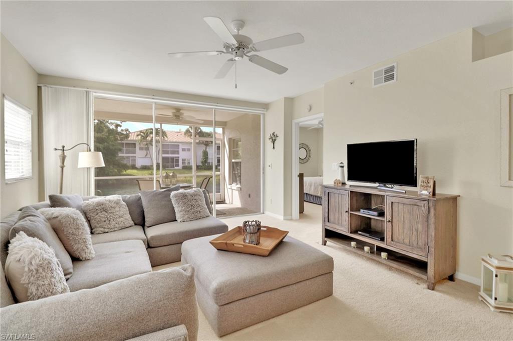 6923 Satinleaf Road North, Unit 101 Naples, FL 34109 - Photo 4 of 50 a living room with furniture and a flat screen tv