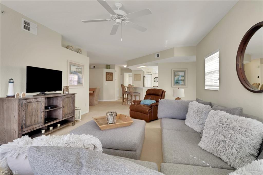 6923 Satinleaf Road North, Unit 101 Naples, FL 34109 - Photo 5 of 50 a living room with furniture and a flat screen tv